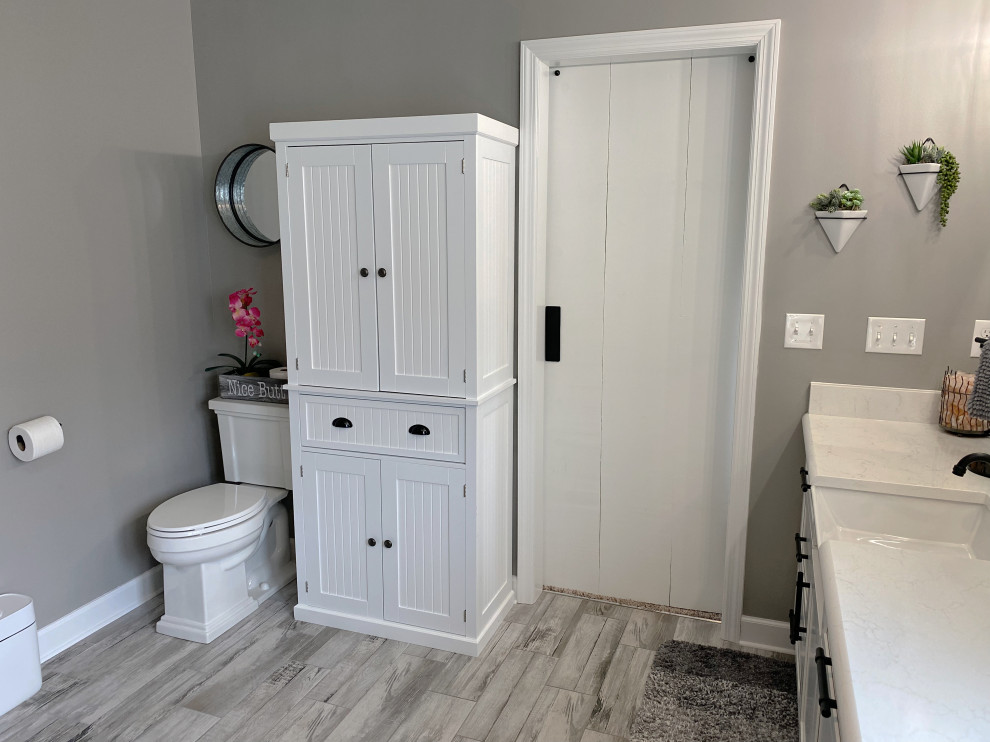 Exempel på ett mellanstort klassiskt vit vitt en-suite badrum, med skåp i shakerstil, vita skåp, en hörndusch, en toalettstol med separat cisternkåpa, grå kakel, klinkergolv i porslin, ett undermonterad handfat, bänkskiva i kvartsit, grått golv och dusch med skjutdörr