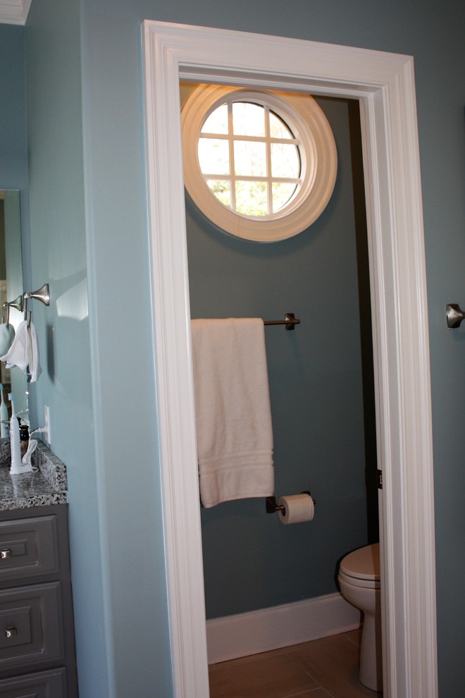 Large transitional master bathroom in Other with a two-piece toilet, blue walls, raised-panel cabinets, grey cabinets, a freestanding tub, a corner shower, gray tile, porcelain tile, porcelain floors, an undermount sink, granite benchtops, grey floor and a hinged shower door.