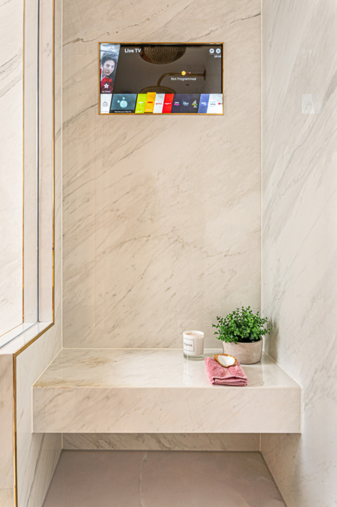 Foto på ett stort funkis vit en-suite badrum, med luckor med glaspanel, vita skåp, en dusch/badkar-kombination, en vägghängd toalettstol, vit kakel, keramikplattor, vita väggar, klinkergolv i keramik, ett integrerad handfat, marmorbänkskiva, rosa golv och dusch med gångjärnsdörr