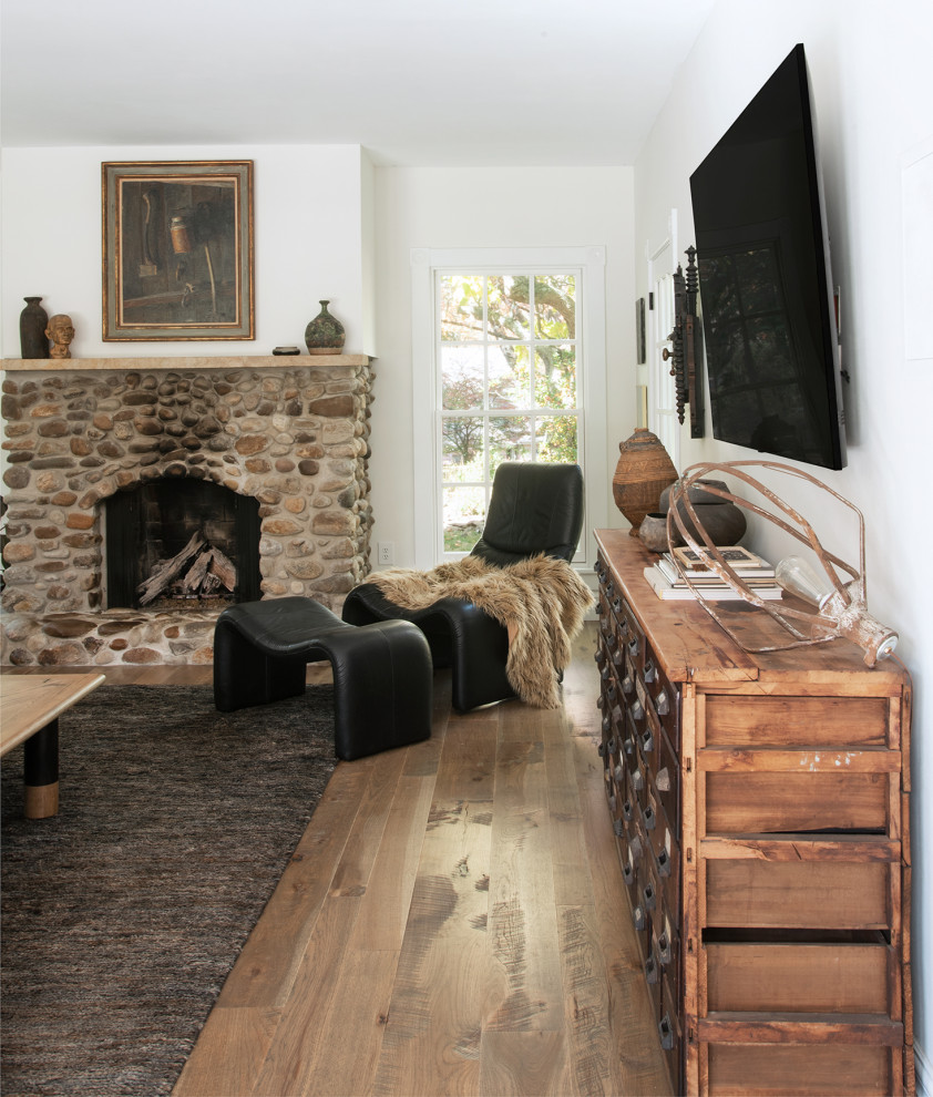 Large country enclosed medium tone wood floor and brown floor family room photo in San Francisco with white walls, a standard fireplace, a stone fireplace and a wall-mounted tv