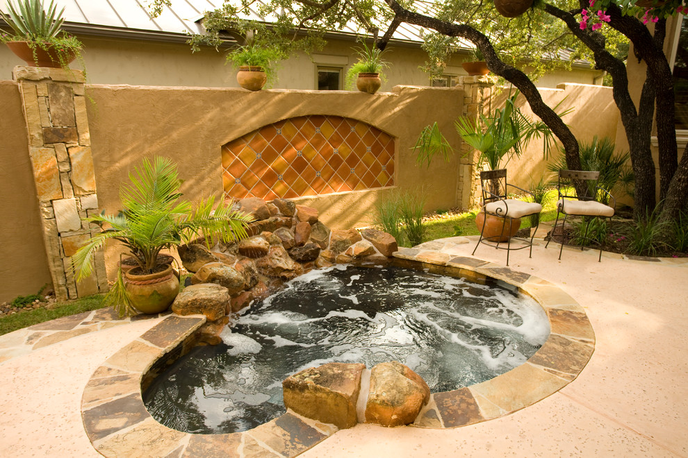 Photo of a mediterranean pool in Austin with a hot tub.