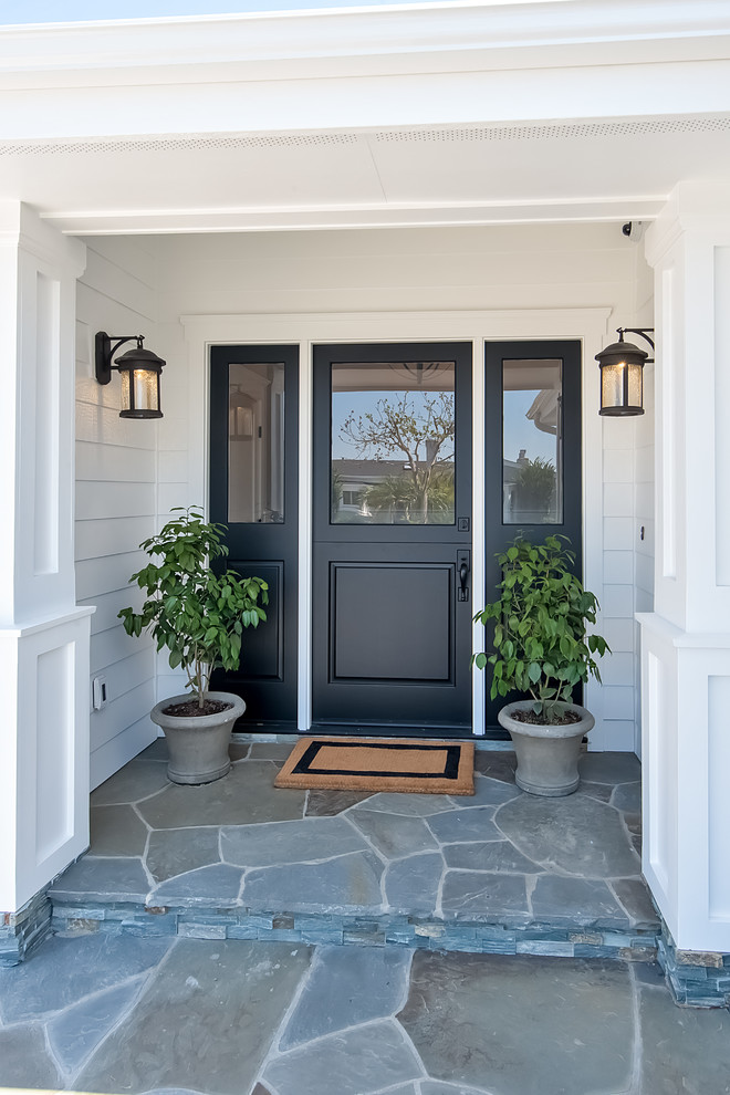Inspiration for a large beach style front door in Orange County with white walls, a dutch front door and a black front door.