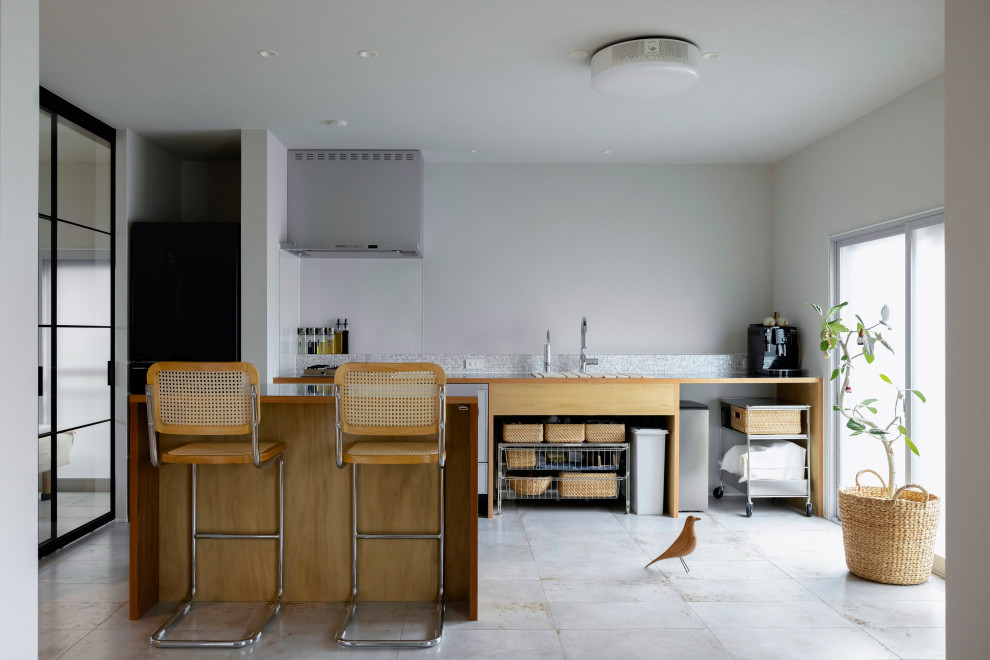 Small country single-wall open plan kitchen in Other with an undermount sink, open cabinets, light wood cabinets, stainless steel benchtops, grey splashback, terra-cotta splashback, coloured appliances, cement tiles, with island, green floor, brown benchtop and wallpaper.