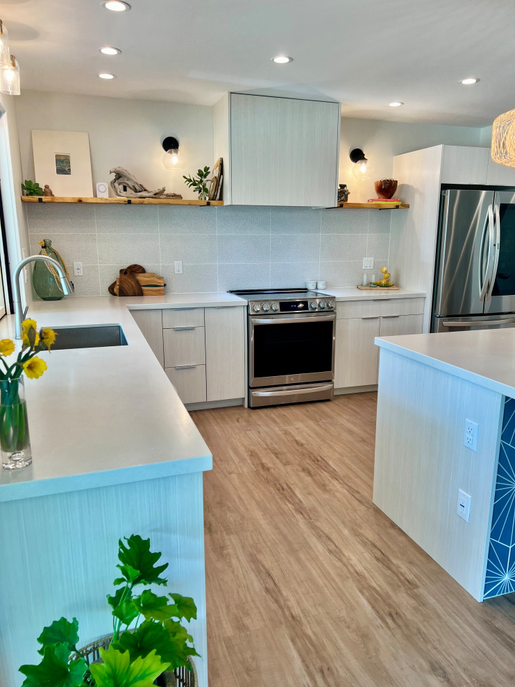 This is an example of a beach style kitchen in Hawaii with flat-panel cabinets and white cabinets.