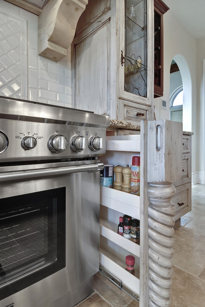 Design ideas for a traditional kitchen in Charleston with an undermount sink, distressed cabinets, white splashback, subway tile splashback and stainless steel appliances.