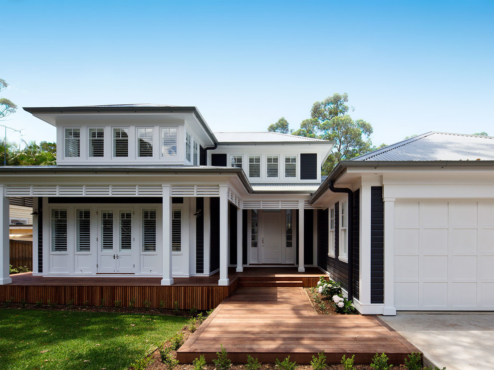 This is an example of a large beach style two-storey black house exterior in Sydney with mixed siding, a hip roof and a metal roof.