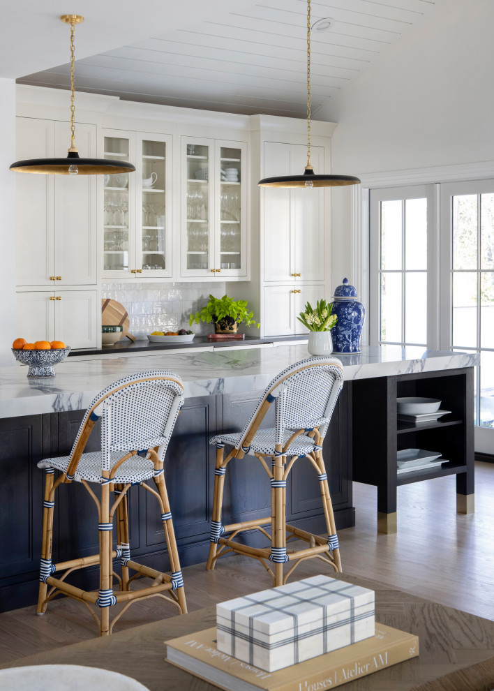 Large transitional galley medium tone wood floor, brown floor and shiplap ceiling open concept kitchen photo in Philadelphia with a farmhouse sink, flat-panel cabinets, white cabinets, quartz countertops, white backsplash, porcelain backsplash, paneled appliances, an island and white countertops