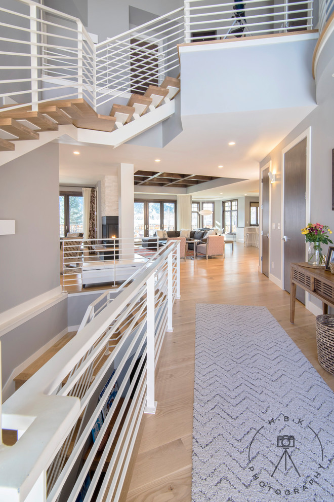 Large light wood floor and beige floor foyer photo with gray walls
