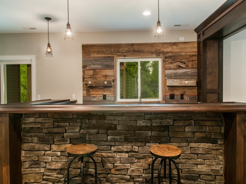 Inspiration for a country l-shaped home bar in Cedar Rapids with brown splashback.