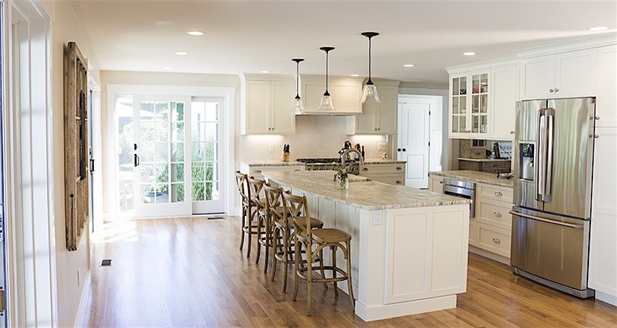 Open concept kitchen - mid-sized transitional galley dark wood floor and brown floor open concept kitchen idea in Boston with a farmhouse sink, shaker cabinets, white cabinets, granite countertops, white backsplash, subway tile backsplash, stainless steel appliances and an island