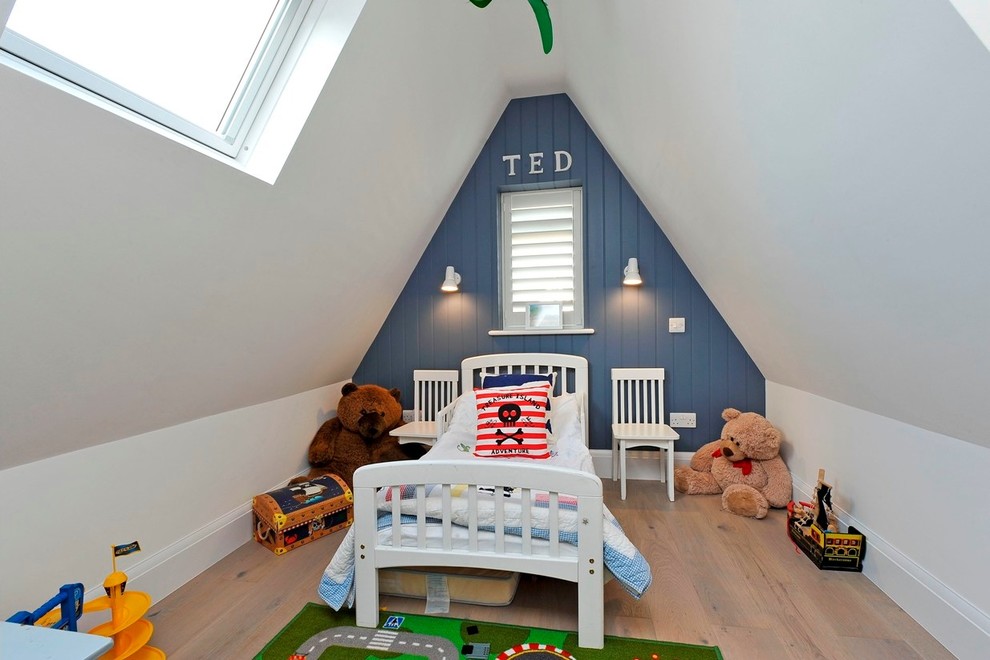 Transitional kids' bedroom in London with white walls and light hardwood floors for kids 4-10 years old and boys.