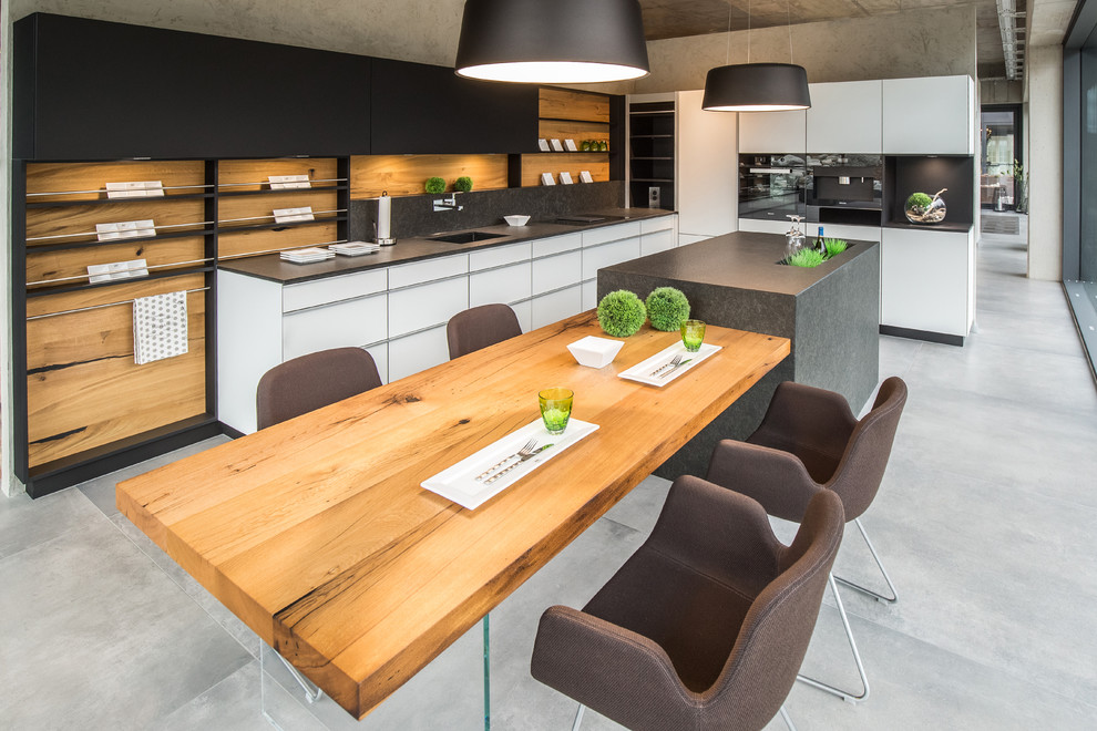 Design ideas for an expansive contemporary l-shaped eat-in kitchen in Frankfurt with an integrated sink, flat-panel cabinets, white cabinets, solid surface benchtops, grey splashback, stainless steel appliances, concrete floors, with island, grey floor and grey benchtop.