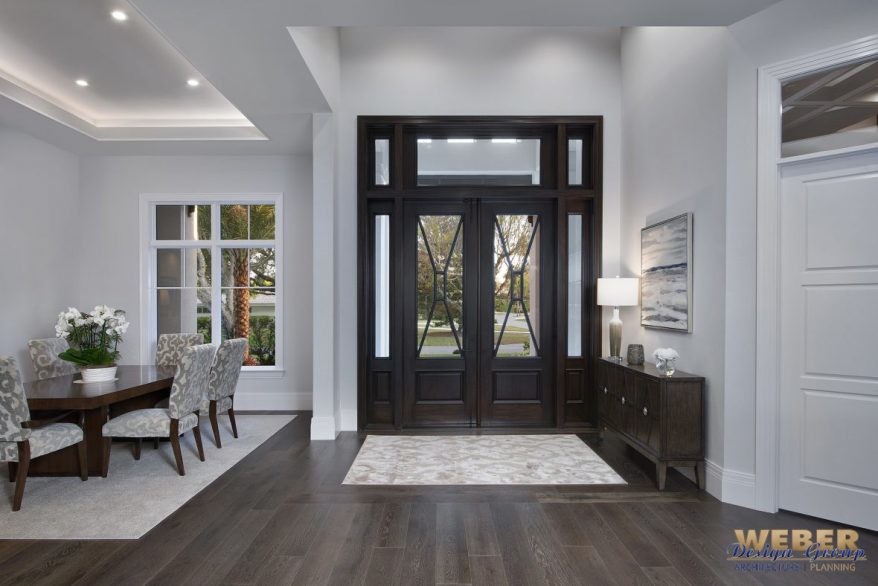 Transitional dark wood floor and black floor foyer photo in Miami with gray walls and a black front door
