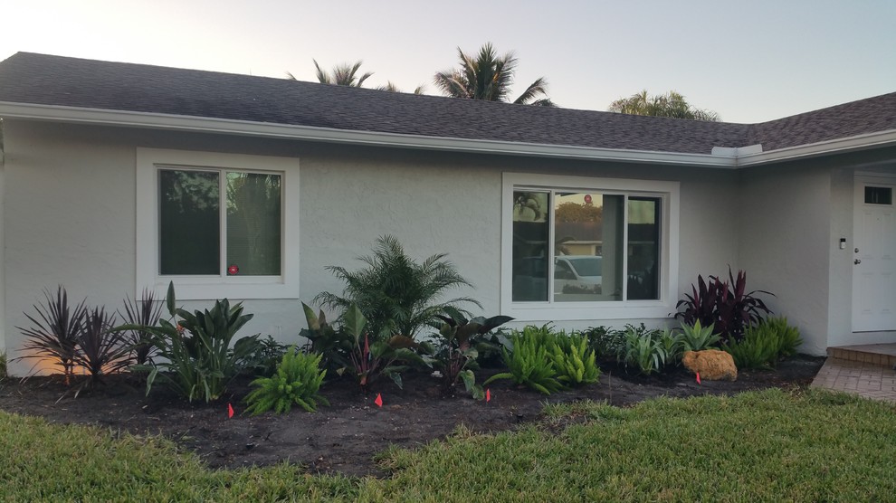 Photo of a mid-sized tropical front yard partial sun formal garden in Miami.