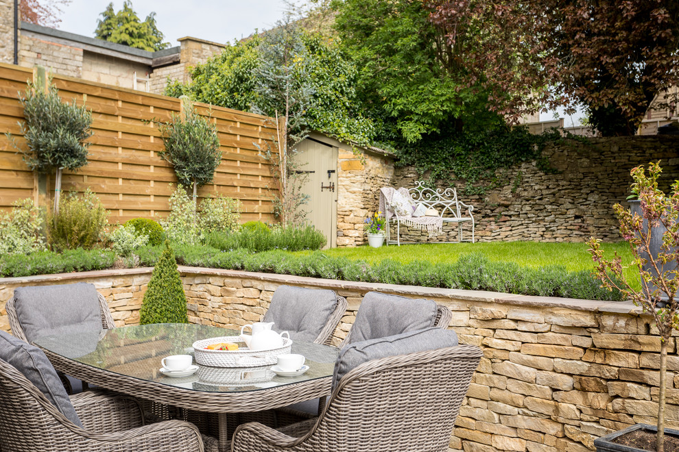 This is an example of a mid-sized country backyard formal garden in Gloucestershire with concrete pavers.