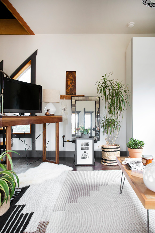 This is an example of an industrial enclosed living room in Nashville with beige walls and brown floor.