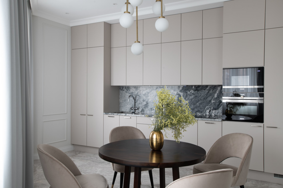 Mid-sized transitional single-wall eat-in kitchen in Moscow with an undermount sink, flat-panel cabinets, beige cabinets, granite benchtops, grey splashback, granite splashback, black appliances, marble floors, no island, grey floor and grey benchtop.