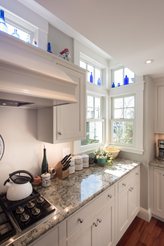 Inspiration for a large transitional u-shaped medium tone wood floor eat-in kitchen remodel in Boston with beaded inset cabinets, white cabinets, granite countertops, white backsplash, stainless steel appliances, an island and gray countertops