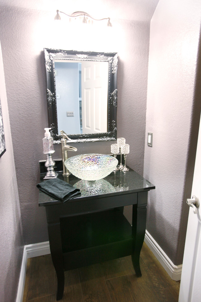 Design ideas for a small transitional powder room in Los Angeles with purple walls, medium hardwood floors, a vessel sink, open cabinets, black cabinets and engineered quartz benchtops.