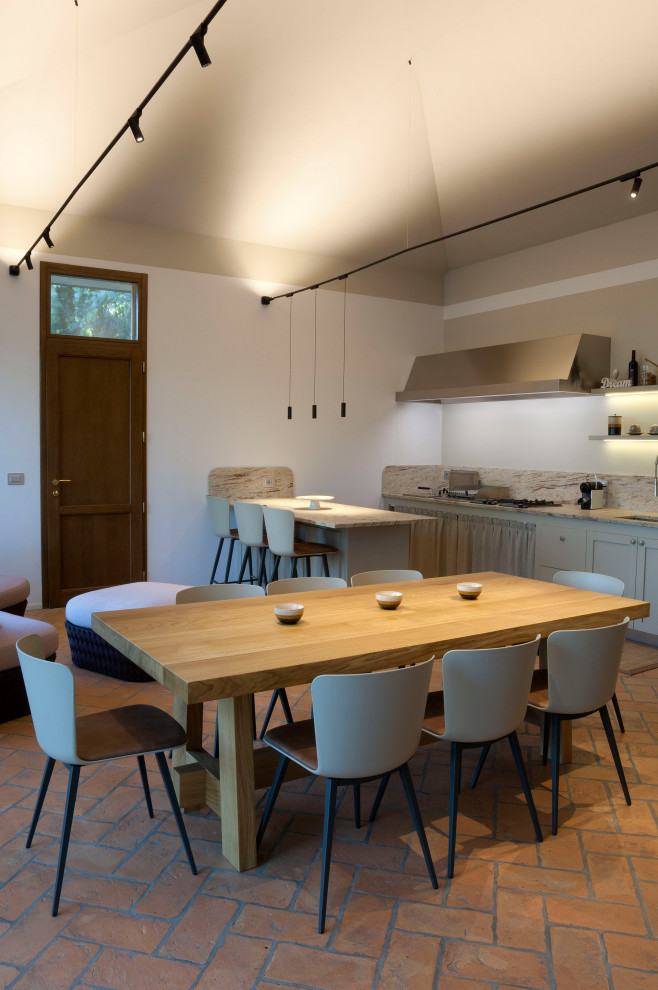 Idee per una grande sala da pranzo aperta verso la cucina stile rurale con pareti bianche, pavimento in mattoni e pavimento arancione