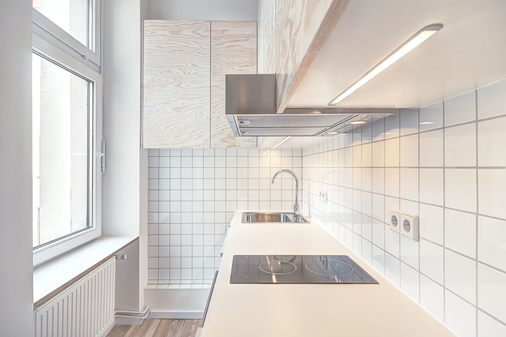 Inspiration for a small contemporary single-wall kitchen in Berlin with flat-panel cabinets, light wood cabinets and white splashback.