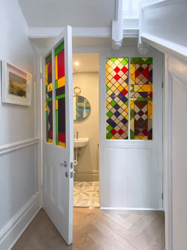 Idée de décoration pour un WC et toilettes design de taille moyenne avec un placard à porte vitrée, un mur gris et un lavabo suspendu.