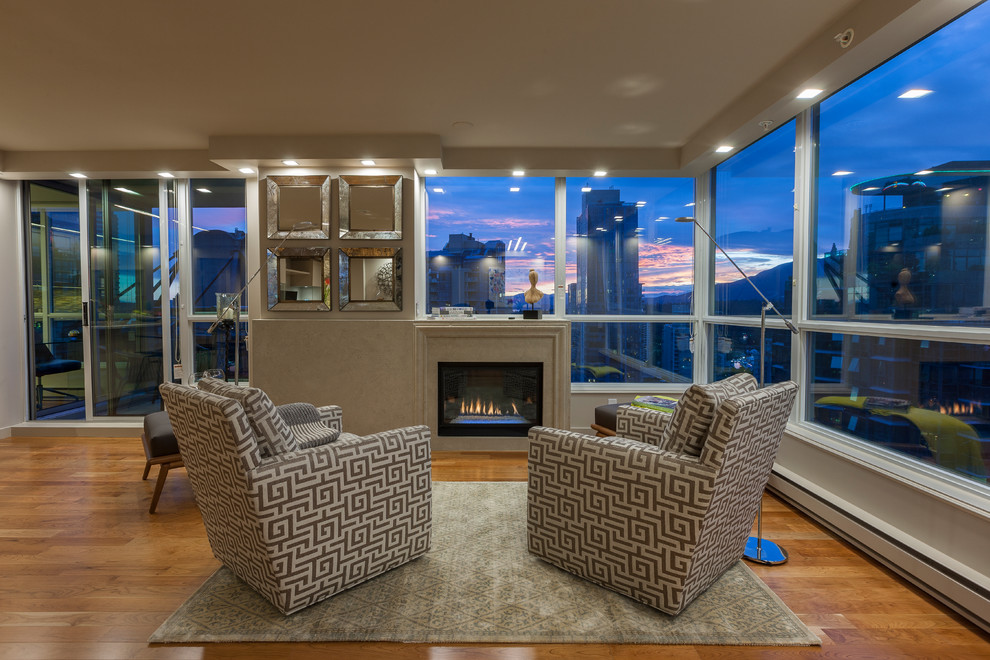 Large contemporary formal open concept living room in Vancouver with beige walls, medium hardwood floors, a standard fireplace, a stone fireplace surround and a wall-mounted tv.