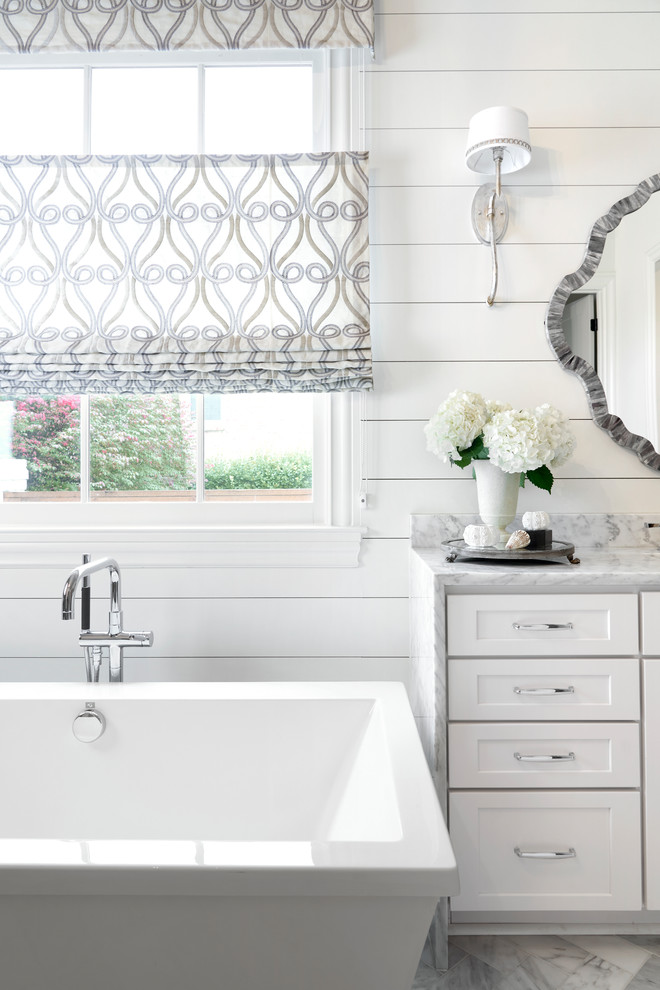 Inspiration for a beach style master bathroom in Nashville with shaker cabinets, white cabinets, a freestanding tub, white walls, marble floors, marble benchtops, grey floor and grey benchtops.