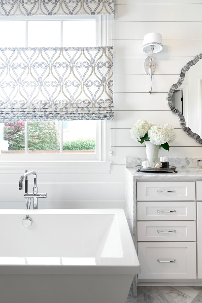 Freestanding bathtub - coastal master marble floor and gray floor freestanding bathtub idea in Nashville with shaker cabinets, white cabinets, white walls, marble countertops and gray countertops