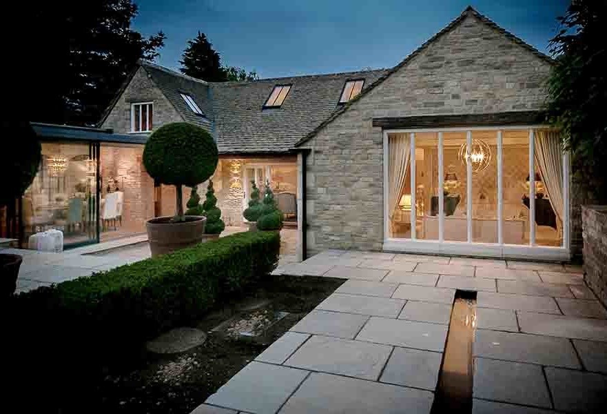 Photo of an expansive country courtyard patio in Oxfordshire with a water feature, natural stone pavers and no cover.