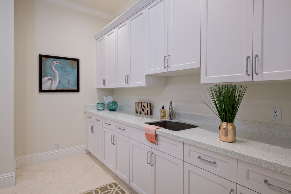 Design ideas for a large traditional galley dedicated laundry room in Miami with an undermount sink, recessed-panel cabinets, white cabinets, quartz benchtops, beige walls and a side-by-side washer and dryer.