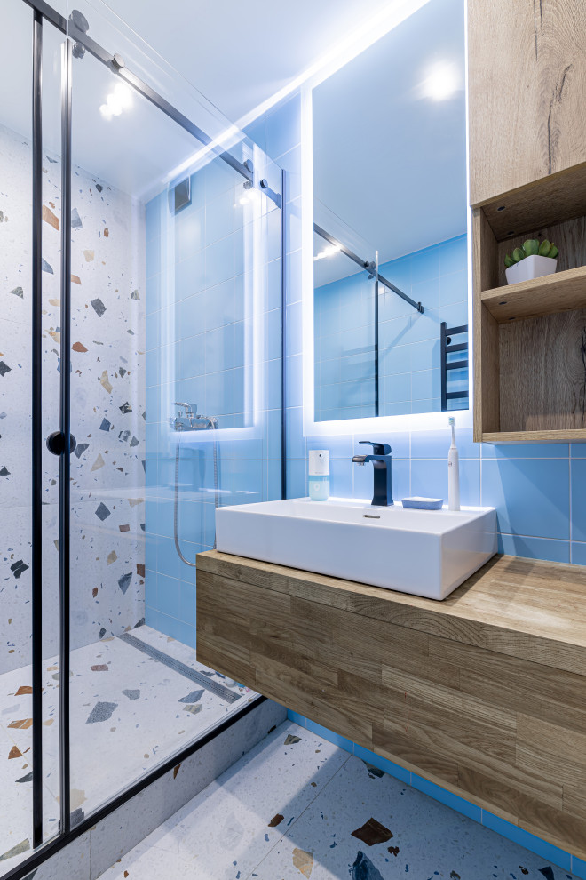 Example of a small trendy 3/4 multicolored tile and ceramic tile ceramic tile, multicolored floor and single-sink bathroom design in Other with flat-panel cabinets, medium tone wood cabinets, blue walls, a vessel sink, wood countertops, brown countertops and a floating vanity
