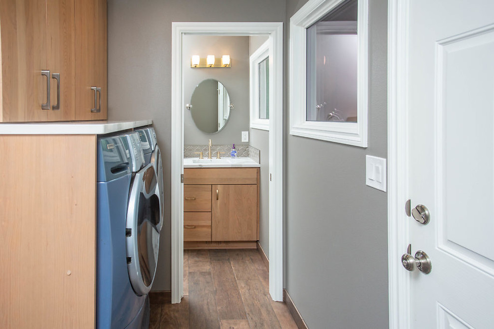 Mid-sized transitional galley eat-in kitchen photo with flat-panel cabinets, medium tone wood cabinets, quartz countertops and stainless steel appliances