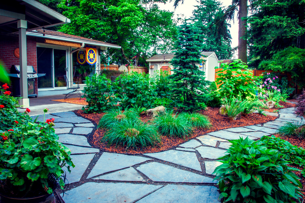 Small midcentury backyard partial sun garden in Portland with a garden path and natural stone pavers for summer.