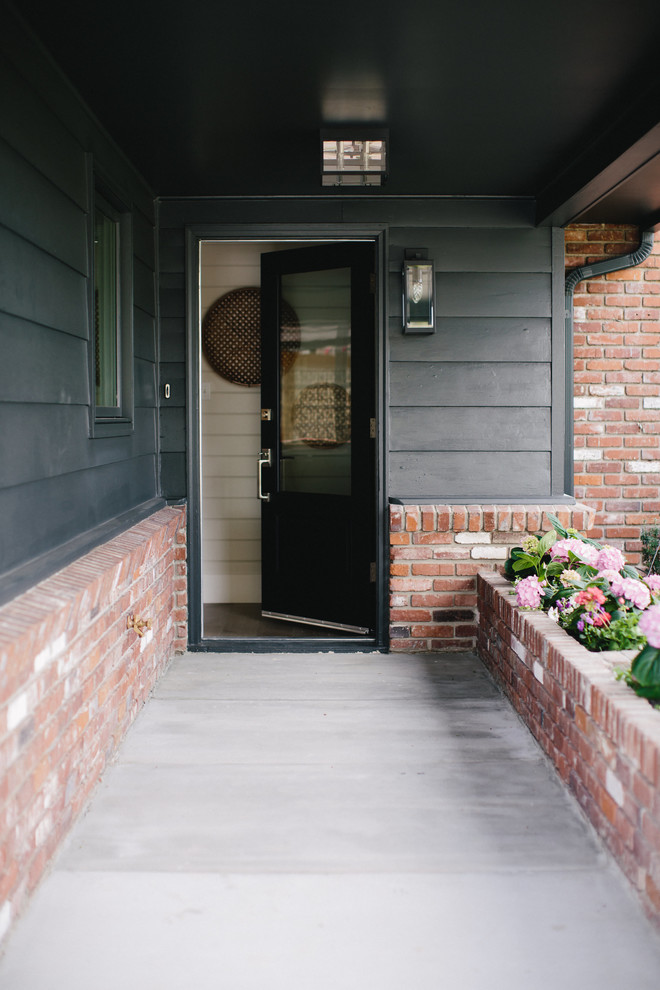 Inspiration for a small transitional single front door remodel with gray walls and a black front door