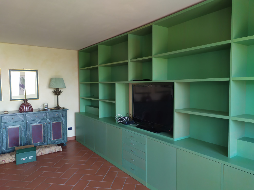 Immagine di un grande soggiorno minimal con libreria, pareti beige, pavimento in gres porcellanato, parete attrezzata e pavimento marrone