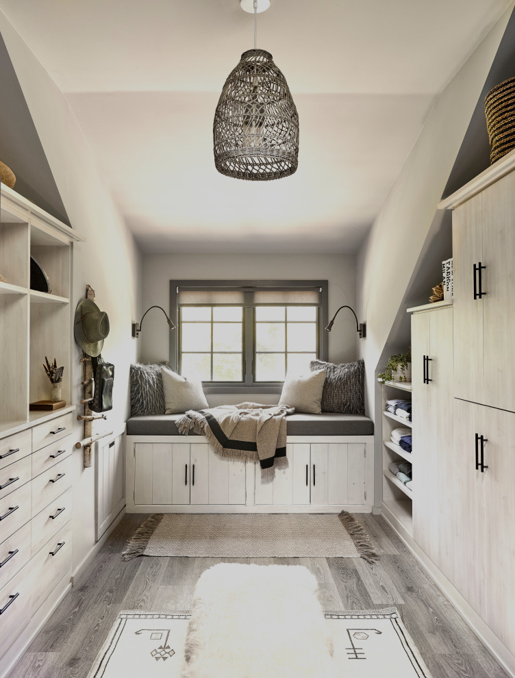 Diseño de armario vestidor unisex y abovedado escandinavo con armarios con paneles lisos, puertas de armario de madera clara, suelo de madera en tonos medios y suelo gris