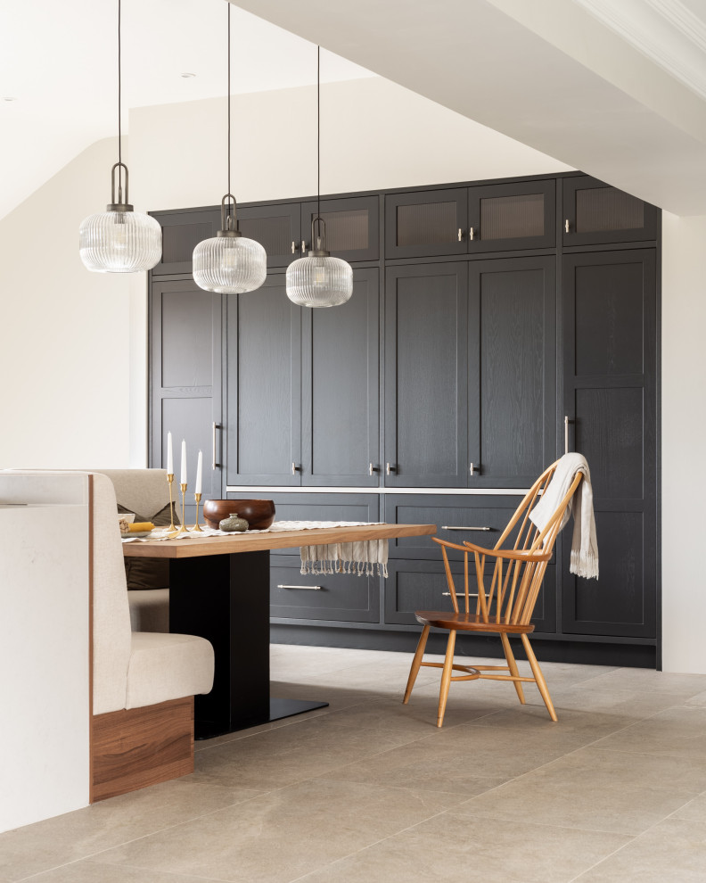 Cette photo montre une grande cuisine ouverte moderne en U avec un évier encastré, un placard à porte shaker, des portes de placard marrons, un plan de travail en quartz, un électroménager noir, sol en béton ciré, îlot, un sol gris et un plan de travail blanc.