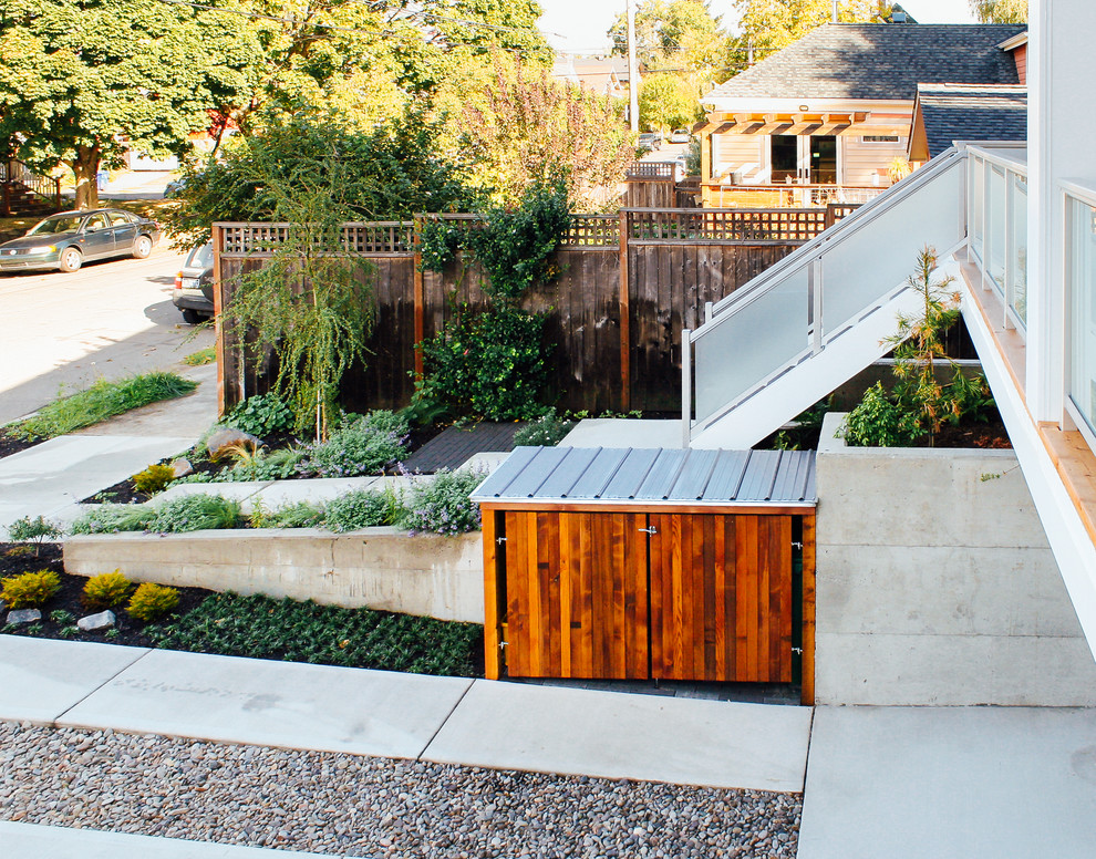 This is an example of a mid-sized modern front yard driveway in Portland with concrete pavers.