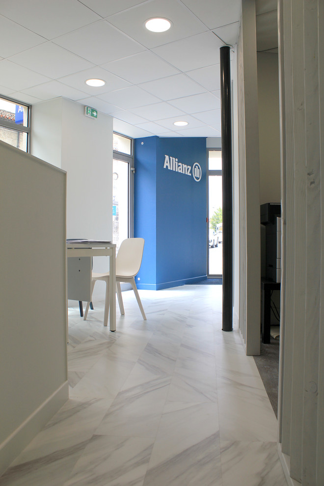 Cette image montre un couloir minimaliste avec un mur bleu et un sol en vinyl.