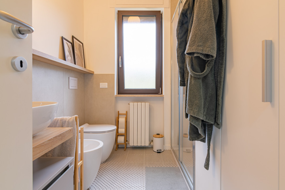На фото: ванная комната среднего размера со стиральной машиной в скандинавском стиле с плоскими фасадами, серыми фасадами, душем без бортиков, раздельным унитазом, серой плиткой, керамогранитной плиткой, белыми стенами, полом из керамогранита, душевой кабиной, настольной раковиной, столешницей из ламината, серым полом, душем с раздвижными дверями, коричневой столешницей, тумбой под одну раковину и напольной тумбой