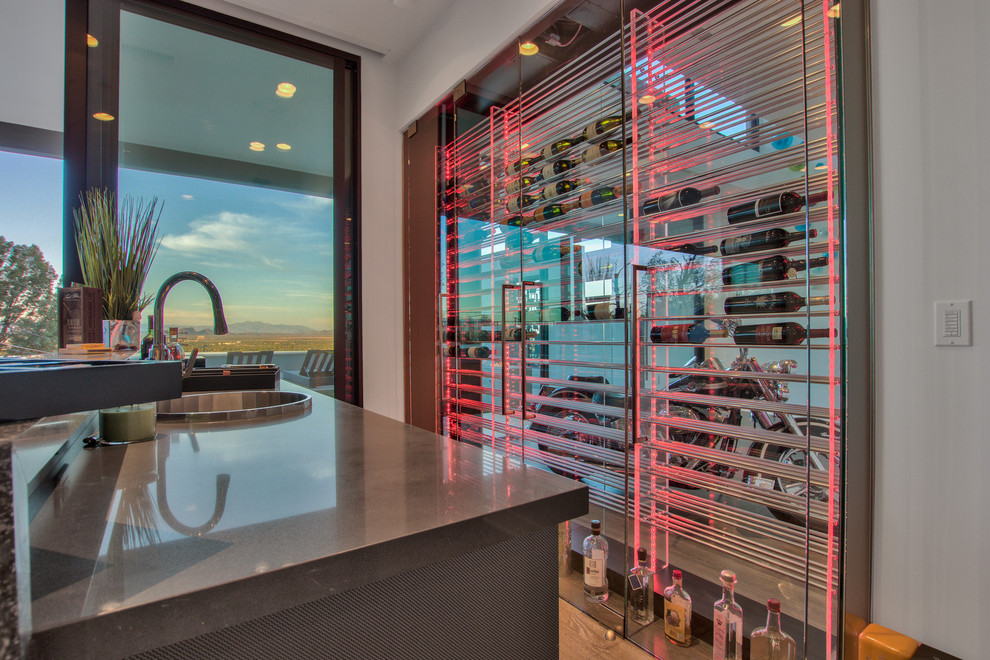 This is an example of a large modern galley wet bar in Phoenix with a drop-in sink, glass-front cabinets, light hardwood floors, concrete benchtops, brown floor and grey benchtop.