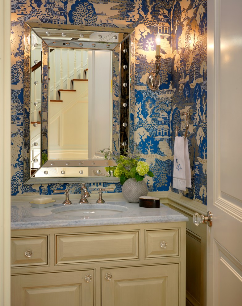 This is an example of a traditional powder room in Boston with an undermount sink, raised-panel cabinets and beige cabinets.