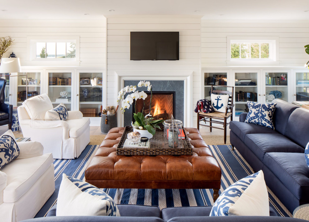 Beach style family room in Orange County with a library, white walls, a standard fireplace and a wall-mounted tv.