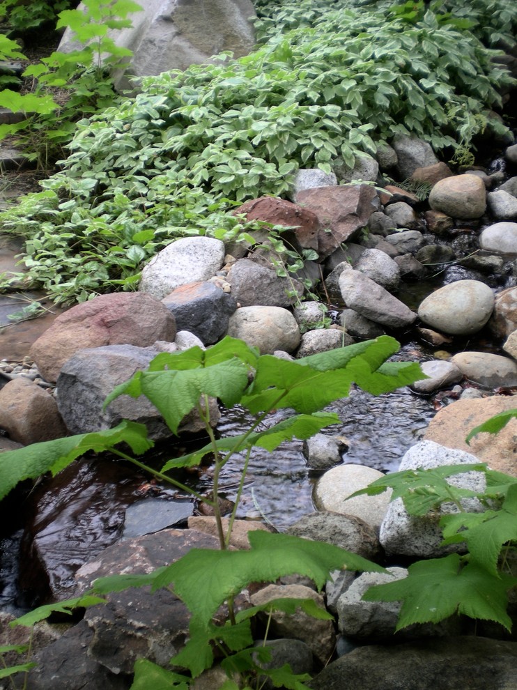 Design ideas for a mid-sized eclectic partial sun backyard water fountain landscape for summer.