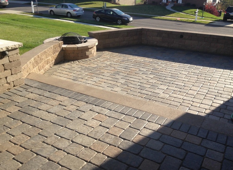 This is an example of a mid-sized transitional partial sun backyard brick landscaping with a fire pit.
