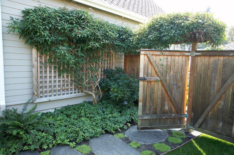 This is an example of a mid-sized contemporary side yard shaded garden for summer in Seattle with a vertical garden and concrete pavers.
