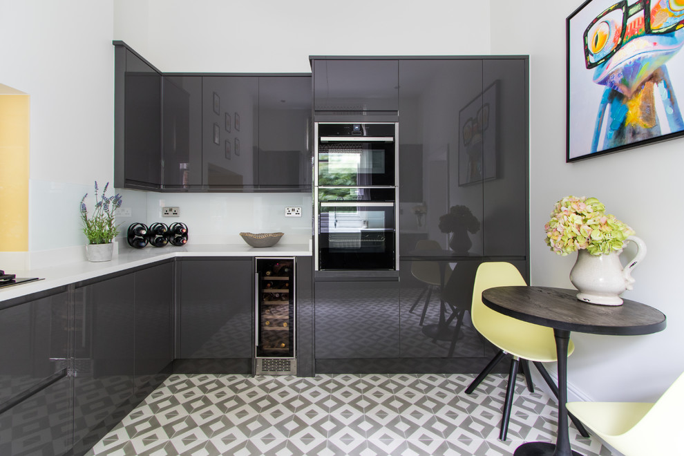 This is an example of a small contemporary u-shaped kitchen in London with flat-panel cabinets, grey cabinets, quartzite benchtops, glass sheet splashback, ceramic floors, no island and multi-coloured floor.