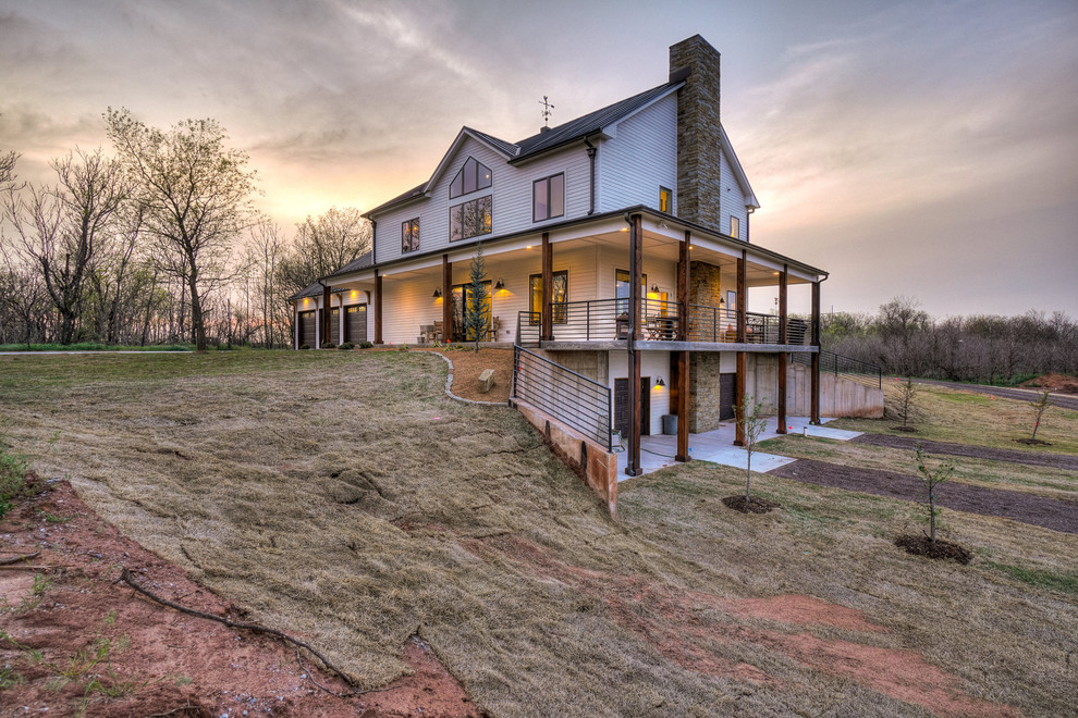 Country two-storey white house exterior in Oklahoma City with a gable roof and a metal roof.