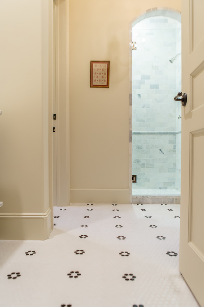 Photo of a mid-sized mediterranean 3/4 bathroom in Houston with furniture-like cabinets, beige cabinets, an alcove shower, a two-piece toilet, gray tile, stone tile, beige walls, mosaic tile floors, an undermount sink and limestone benchtops.